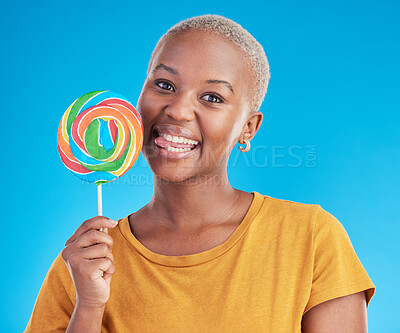 Buy stock photo Lollipop, portrait and a woman with candy in studio for sweets, rainbow and creative advertising. Happy black female person isolated on a blue background with sugar, freedom or happiness and tongue
