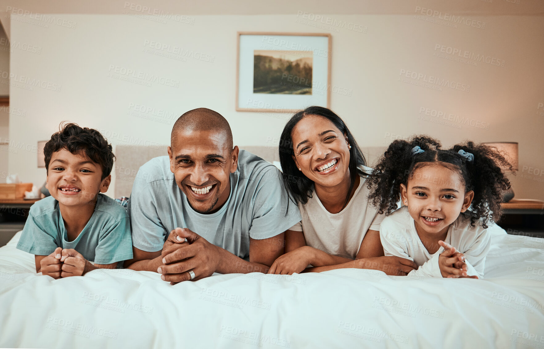 Buy stock photo Happy, smile and portrait of a family on a bed for relaxing, resting and bonding together. Happiness, love and children laying with their young mother and father in the bedroom of their modern home.