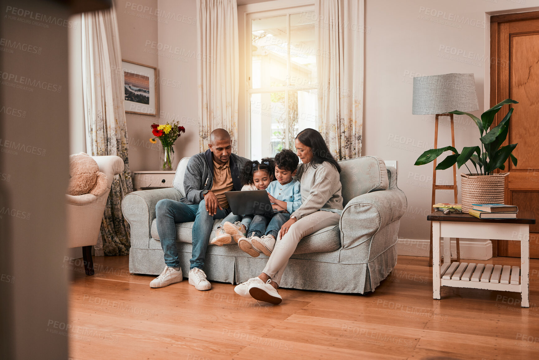 Buy stock photo Laptop, sofa and family watching a movie online together in the living room of their home. Relax, technology and cute children streaming film, show or video on a computer with their parents in house.