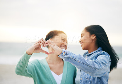 Buy stock photo Love, ocean and lesbian couple with heart hands on summer holiday adventure or sunset date together. Lgbt women, bonding and relax on ocean vacation with romance, pride and happy partner in nature.