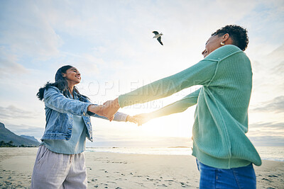 Buy stock photo Holding hands, happy and a lesbian couple at the beach for trust, love and care on a holiday. Smile, summer and lgbt women with freedom, support and love at the sea on a date, vacation or together