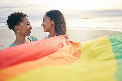 Buy stock photo Pride flag, lesbian couple and freedom smile at beach for romance, happy or care in nature. Rainbow, love and women at ocean embrace lgbt, gay or partner pride, date or romantic relationship moment
