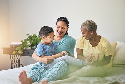 Buy stock photo Playing, gay family and morning in bed or home bedroom for security, quality time and love. Adoption, lesbian or LGBTQ women or parents and happy kid together to wake up with tickle, care or fun game