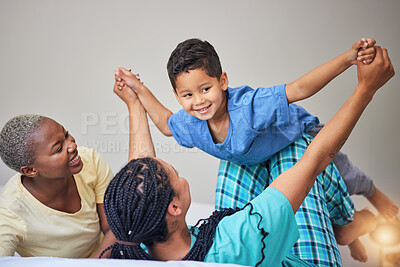 Buy stock photo Child, gay family and playing on bed in home bedroom for security, quality time and love. Adoption, lesbian or LGBTQ women or parents lift a happy kid to wake up with care, fun game and a smile