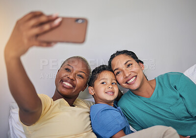 Buy stock photo Gay family, happy and selfie in bed with foster boy child, bond and relax at home. Adoption, lesbian women and social media lgbt influencer smile for profile picture, blog or podcast post in bedroom