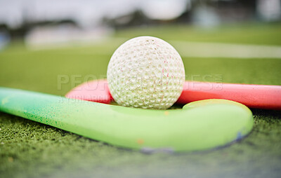 Buy stock photo Hockey, stick and ball on a field for a game, training or exercise for sports. Closeup, ground and gear or equipment for fitness, challenge or a competition on the grass of a park for action