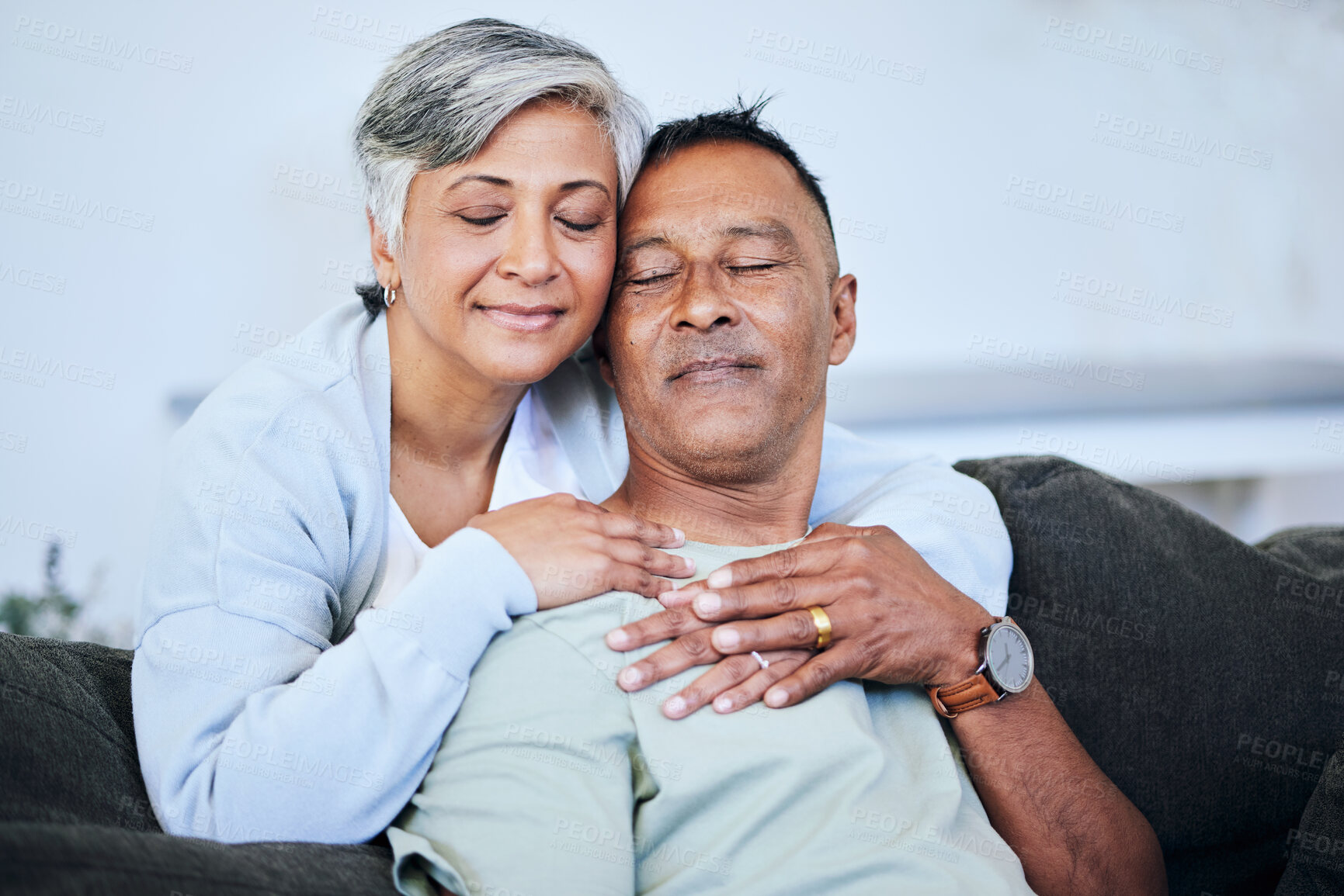 Buy stock photo Love, romance and a senior couple on a sofa in the living room of their home together during retirement. Happy, relax and hug with an elderly woman embracing her husband for comfort in a house