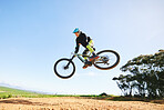 Mountain bike, man and jump in blue sky for action, stunt performance and speed on mockup space. Bicycle, sports athlete and courage in air for freedom, risk or race in cycling competition with power