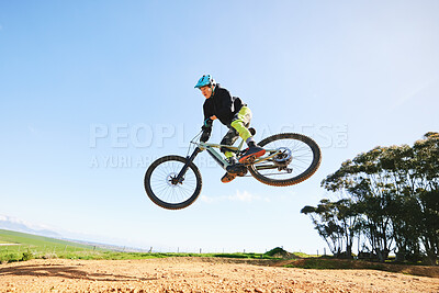 Buy stock photo Mountain bike, man and jump in blue sky for action, stunt performance and speed on mockup space. Bicycle, sports athlete and courage in air for freedom, risk or race in cycling competition with power