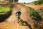 Cycling, sports and man in nature on bicycle for adrenaline on adventure, freedom and speed. Mountain bike, countryside and cyclist for training, exercise and fitness on dirt road, trail and track