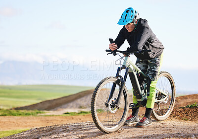 Buy stock photo Fitness, nature and man cycling with phone for direction, social media or reading a notification. Sports, communication and cyclist or person on a bike with a mobile app for progress in the mountains