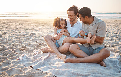 Buy stock photo Gay parents, father and girl at beach with love, smile and hug for vacation, laugh or outdoor on sand in sunset. LGBTQ men, young kid and adoption with family, holiday or comic conversation in summer