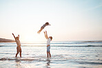 Father, lifting and child in air at beach, sunset and waves in the ocean for happiness, fun and support on adventure. Parents, kid and silhouette of dad in the sea with love to play a game with girl