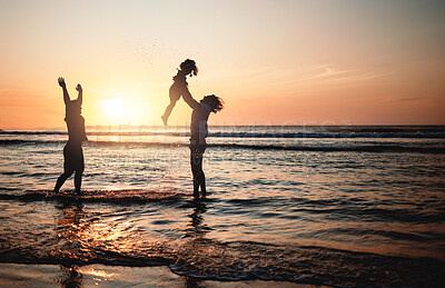 Buy stock photo Silhouette, sunset and dad lifting child in air at beach with lgbt family and waves in the ocean with fun and support on adventure. Gay parents, kid and father play with girl in the sea with love