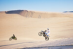 Bike, sand and freedom with people in the desert for adrenaline, adventure or training in nature. Moto, sports and balance with friends on dirt in summer for a race competition or training on space