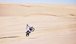 Bike, sand and fitness with a man in the desert for adrenaline, adventure or training in nature. Motorcycle, speed and balance with an athlete riding a sports vehicle on space in summer for freedom