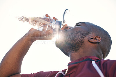 Buy stock photo Black man, drinking water and health with fitness, athlete and sports with hydration and sunshine. African male person, beverage in bottle and wellness with exercise, lens flare and low angle