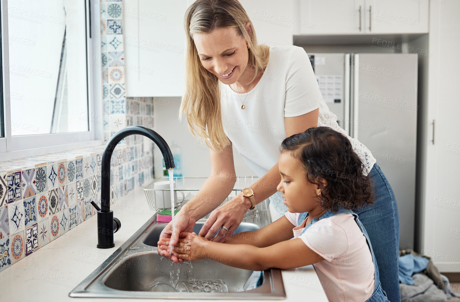 Buy stock photo Mother, child and washing hands at kitchen sink at home for good hygiene, health and wellness. A woman and kid or daughter learning skin care, cleaning and safety from germs or dirt at family house