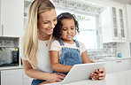 Blended family, adoption and a mother with her daughter on a tablet in the kitchen for education or study. Children, diversity and learning with woman teaching her girl kid in their home together