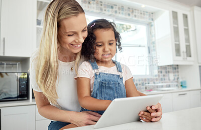 Buy stock photo Blended family, adoption and a mother with her daughter on a tablet in the kitchen for education or study. Children, diversity and learning with woman teaching her girl kid in their home together