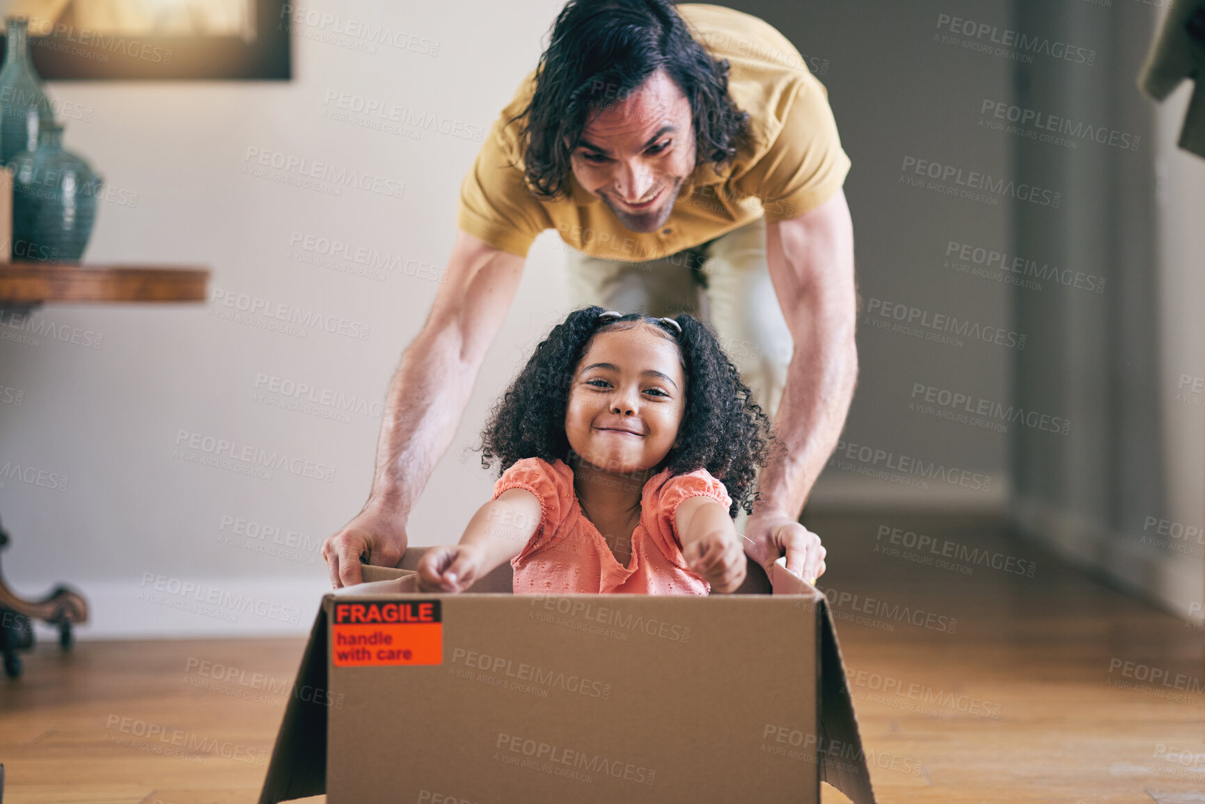 Buy stock photo Father, kid and box in new house for games, fun and energy for bonding in real estate apartment. Happy dad, girl child and interracial family play with cardboard boxes for race while moving to home