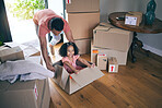 Dad, child and box in new home for games, fun and freedom on floor of real estate property from above. Happy father, excited family and girl kid play in cardboard boxes for race while moving in house