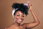 Comb, hair care or portrait of black woman with afro, self love or smile on a brown studio background. Hairstyle, beauty or happy African model with natural shine or volume with aesthetic or wellness