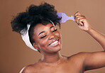 Comb, hair care or happy black woman with afro, self love or smile on a brown studio background. Hairstyle, healthy growth or African model with natural shine or beauty with aesthetic or wellness