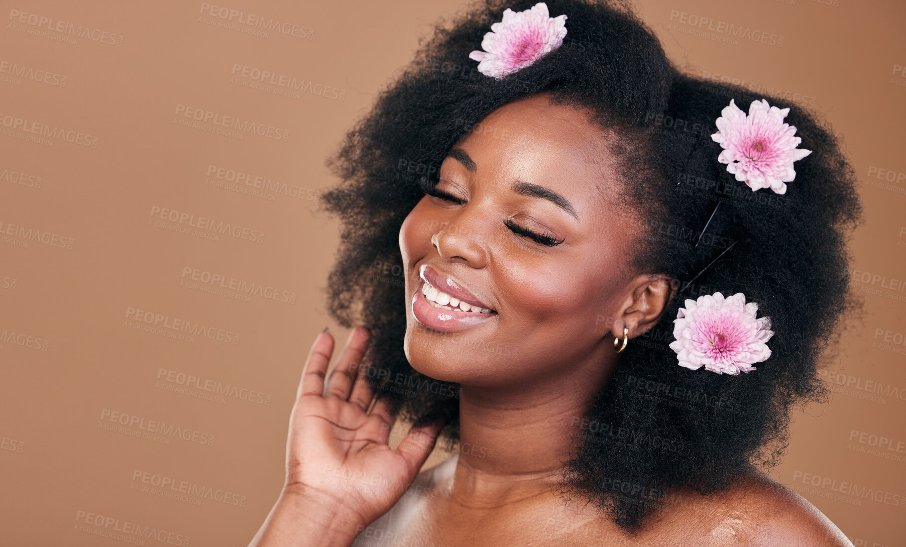 Buy stock photo Hair care, flowers and black woman in afro, smile and beauty in studio isolated on brown background mockup space. Floral plant, hairstyle cosmetic and natural African model in organic salon treatment