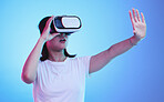 Metaverse, headset and a woman on a blue background, touching for experience and gaming. Virtual reality, digital and a girl with glasses for a 3d online game or entertainment on a studio backdrop