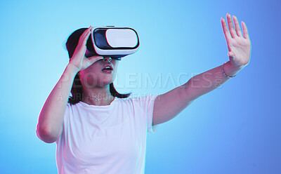Buy stock photo Metaverse, headset and a woman on a blue background, touching for experience and VR gaming. Virtual reality, digital and a girl with glasses for a 3d online game or entertainment on a studio backdrop