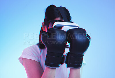 Buy stock photo Vr, fitness and woman boxing in esports, video game and fight in studio on blue background with headset technology. 3d, exercise and virtual reality fighting ux or punching with futuristic gaming