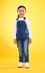 Happy, portrait and girl child for fashion in studio with confidence, smile and positive attitude. Excited, clothes and young kid with happiness, pose and casual style isolated on a yellow background