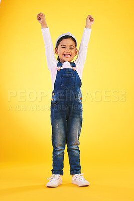 Buy stock photo Portrait, children and a winner girl on a yellow background in celebration of success or victory. Kids, goals and motivation with a young child cheering for an award or achievement in studio