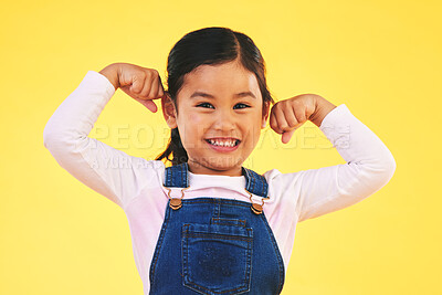 Buy stock photo Happy, portrait and girl child with arm flex in studio for confidence, strong and power on yellow background. Face, smile excited kid with bicep strength, pose and empowered, positive and growth sign