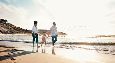 Buy stock photo Walking, holding hands and family on the beach at sunset on vacation, adventure or holiday together. Travel, bonding and girl child with her mother and father on the sand by the ocean on weekend trip