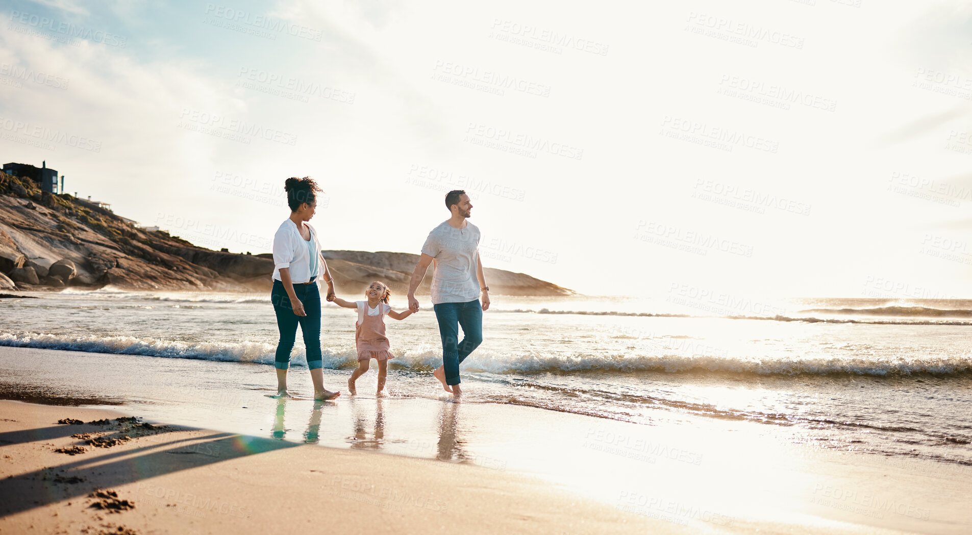 Buy stock photo Walking, holding hands and family on the beach at sunset on vacation, adventure or holiday together. Travel, bonding and girl child with her mother and father on the sand by the ocean on weekend trip