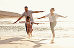 Family, running in ocean and freedom on beach with sunshine, fun together with games and bonding on vacation. Travel, adventure and playful, parents and child with happy people in nature and energy