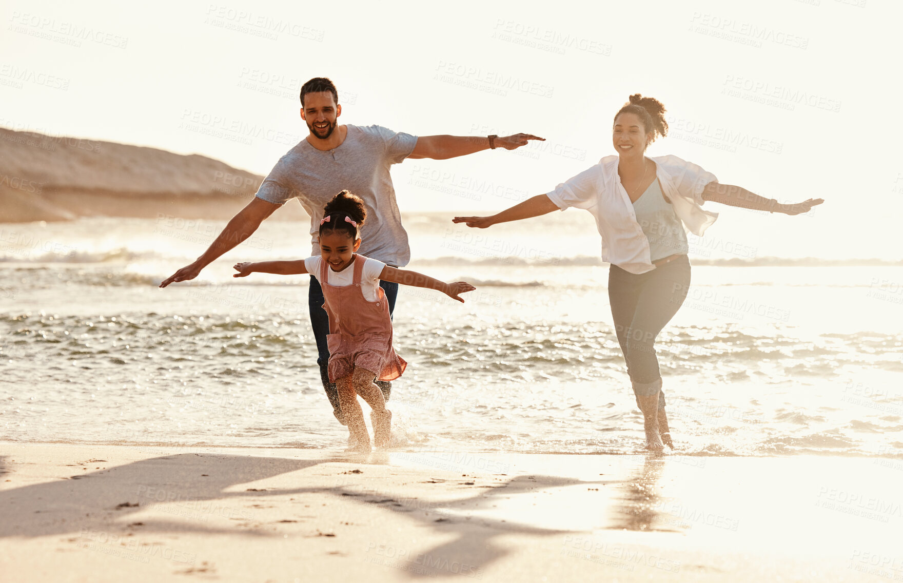 Buy stock photo Family, running in ocean and freedom on beach with sunshine, fun together with games and bonding on vacation. Travel, adventure and playful, parents and child with happy people in nature and energy