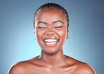 Beauty, skincare and black woman with laughing, cosmetics and makeup in studio. Wellness, African female model and joke with blue background and skin glow with shine from dermatology and treatment