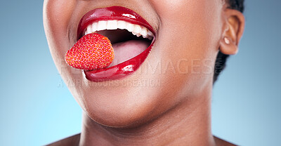 Buy stock photo Woman, eating and strawberry, red lipstick and beauty, makeup closeup isolated on blue background. Fruit, healthy and model in a studio with bold cosmetic product, mouth and cosmetology with shine