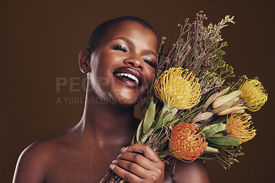 Buy stock photo Skincare, smile and protea with the face of a black woman in studio on brown background for natural treatment. Beauty, plant or cosmetics and a young model posing for aesthetic wellness with flowers