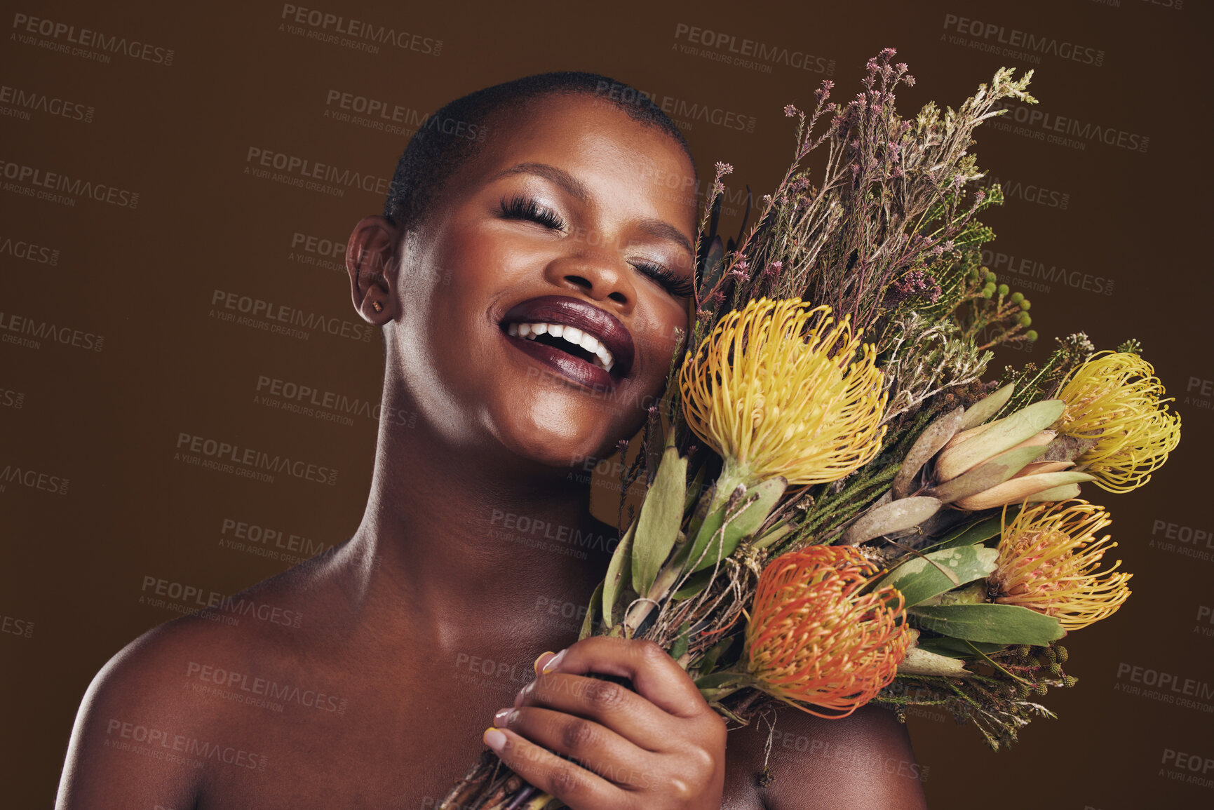 Buy stock photo Skincare, smile and protea with the face of a black woman in studio on brown background for natural treatment. Beauty, plant or cosmetics and a young model posing for aesthetic wellness with flowers