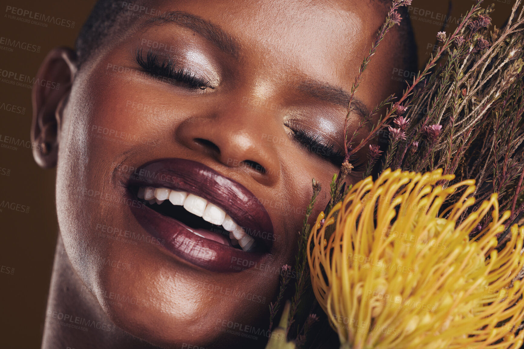 Buy stock photo Skincare, beauty and plant with the face of a black woman in studio on brown background for natural treatment. Smile, protea or cosmetics and a young model indoor for aesthetic wellness with flowers