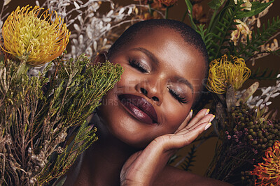 Buy stock photo Black woman, flowers and beauty with face, smile with makeup and natural cosmetics with hand touching skin. African model, plants and nature, sustainable skincare and eyes closed, facial and glow