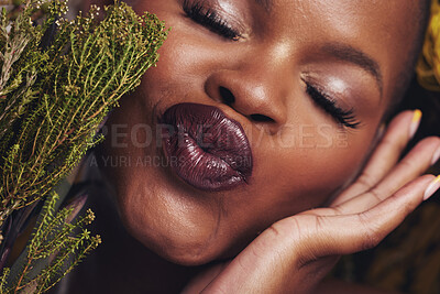 Buy stock photo African woman, plants and makeup in studio with kiss, beauty and wellness with lipstick, skin and closeup. Girl, model and face with leaves, pouting or happy for cosmetics, shine or aesthetic in zoom