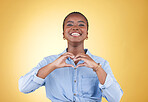 Portrait, heart hands and black woman, smile and studio isolated on yellow background. Face, love sign and happy African person in kindness, care and empathy, support and trust, romance or solidarity