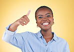 Black woman, smile in portrait and thumbs up, feedback and support isolated on yellow background. Happy, agreement and hand gesture with positive review, yes and like emoji with success in a studio