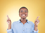 Wish sign, fingers crossed and portrait of black woman in studio smile for hope, winning and success. Emoji, excited  and face of African person on yellow background with hand gesture for miracle