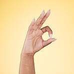 Perfect, ok and hand sign  in studio with decision, agreement and success of good news. Yellow background, yes vote and accept approval of a person showing agree, opinion and emoji icon and signal